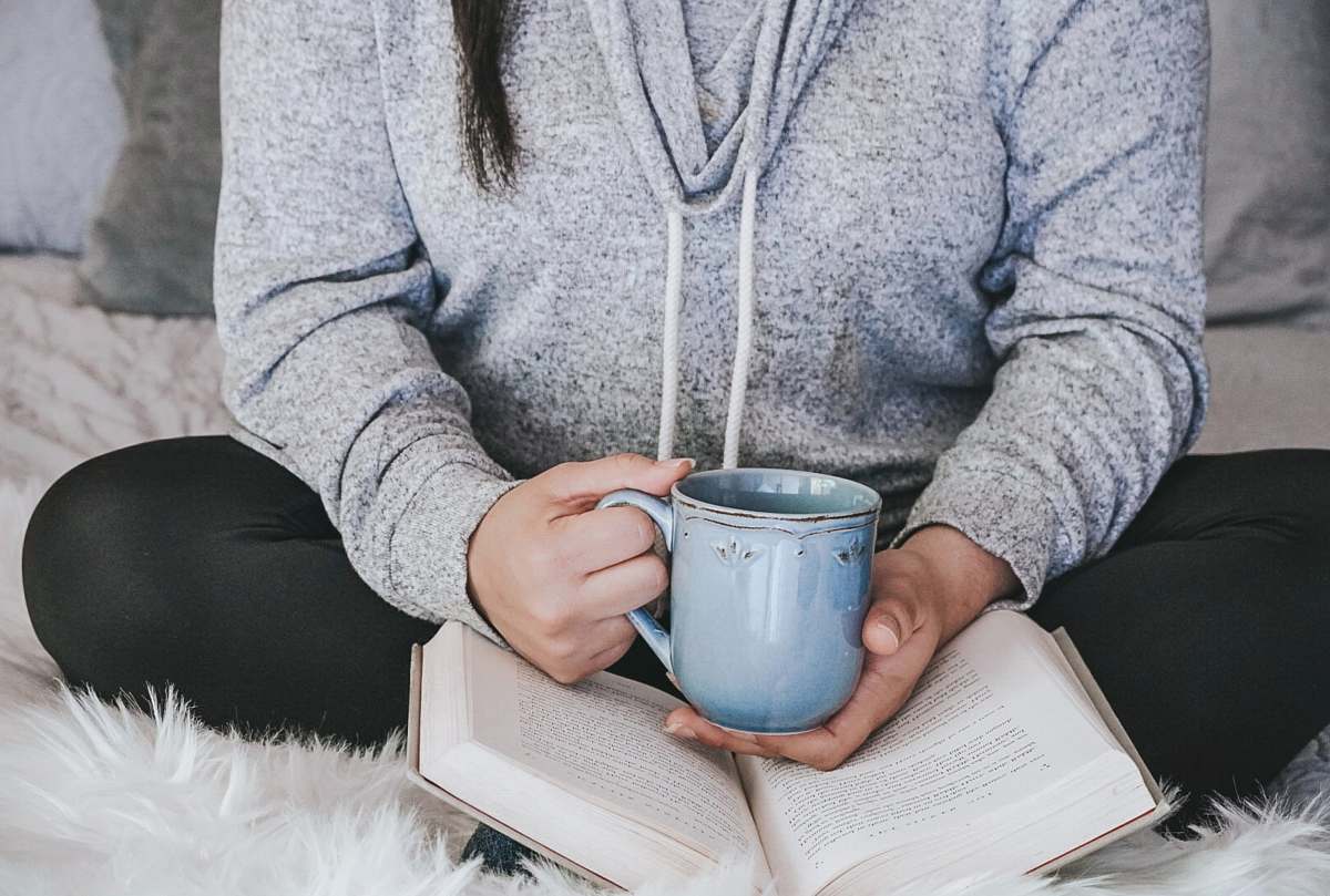 coffee cup person in gray sweater holding white ceramic mug cup